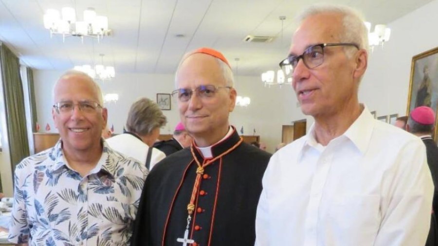 El papa León XIV posa en atuendo eclesiástico junto a su hermano Louis Prevost y un acompañante en un salón de recepciones.